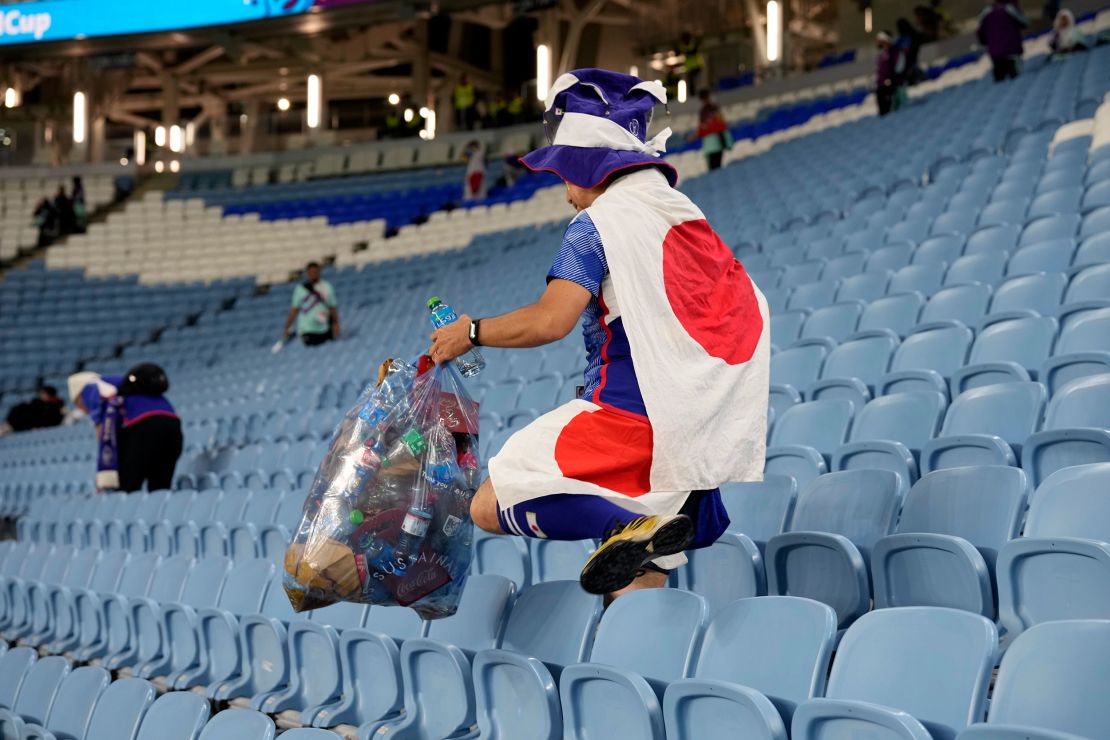 A fan of Japan collects garbage at the end of the World Cup match against Croatia at the Al Janoub Stadium in Al Wakrah, Qatar.