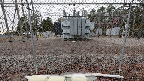 Barriers designed to absorb oil are placed near a damaged transformer hit by gunfire in Carthage, North Carolina.