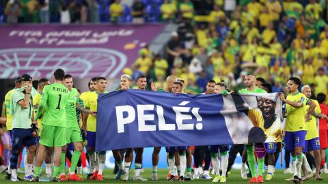 12 月 5 日に行われたカタール 2022 ワールド カップ ラウンド 16 の試合後、元ブラジル代表選手のペレへの支持を示す横断幕を掲げるブラジルの選手たち。 