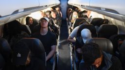 Airline passengers, some not wearing face masks following the end of Covid-19 public transportation rules, sit during a American Airlines flight operated by SkyWest Airlines from Los Angeles International Airport (LAX) in California to Denver, Colorado on April 19, 2022. - Mask mandates on public transportation are no longer in effect following a ruling by federal judge on April 18, 2022. (Photo by Patrick T. FALLON / AFP) (Photo by PATRICK T. FALLON/AFP via Getty Images)