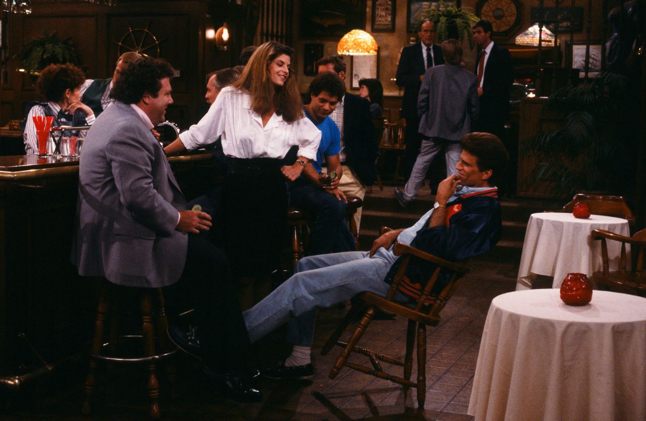 George Wendt, Alley, and Ted Danson in a scene in the hit NBC TV show "Cheers." Alley, who joined the cast in 1987, played the role of Rebecca Howe, which catapulted her to stardom. 