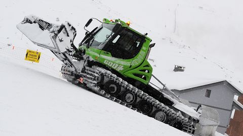 A hybrid green snow groomer clears snow in Val Thorens, in the French Alps.