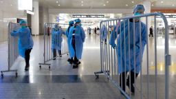 Covid-19 control workers move away barriers used during virus screening at a railway station in Hangzhou in east China's Zhejiang province on Monday. 