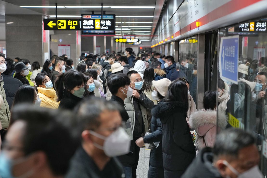 Citizens wearing masks board a subway train on Monday in Henan province's Zhengzhou. Negative Covid-19 test results are no longer required for riding public transport.