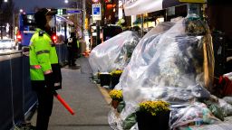 A police officer stands guard near floral tributes at the scene of a crowd crush that happened during Halloween festivities, in Seoul, South Korea, November 29, 2022. 