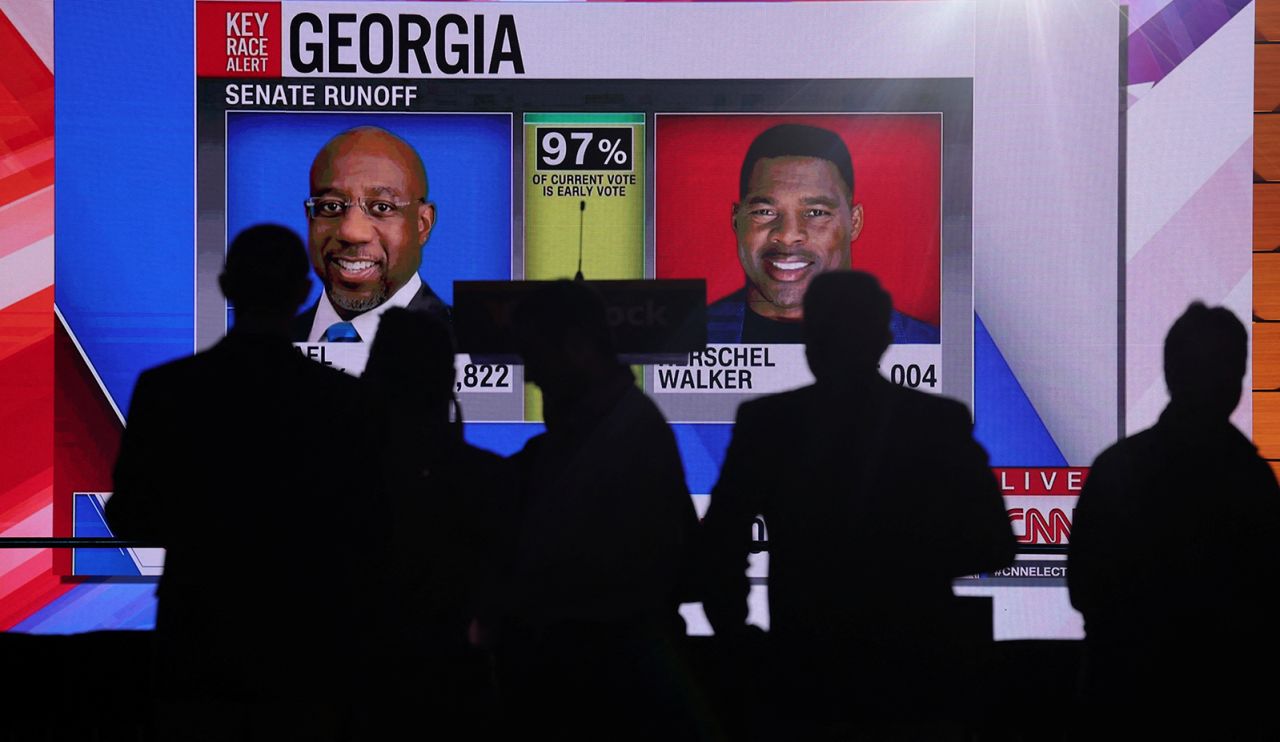 People in Atlanta watch as results come in Tuesday night for the Senate runoff in Georgia.