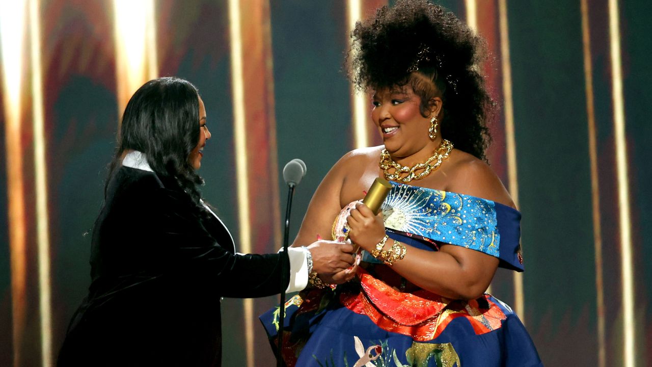 Shari Johnson-Jefferson presents the The People's Champion award to honoree Lizzo on stage during the 2022 People's Choice Awards held at the Barker Hangar on December 6, 2022 in Santa Monica, California.