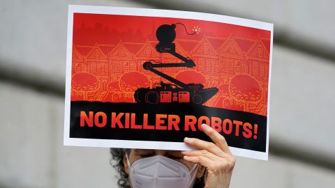 A woman holds up a sign while taking part in a demonstration about the use of robots by the San Francisco Police Department outside of City Hall Monday.