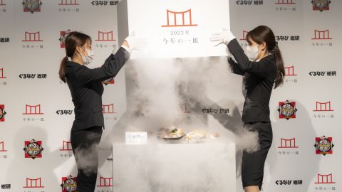 Two Gurunavi Research Institute employees unveil the "dish of the year" at a press event in Tokyo.