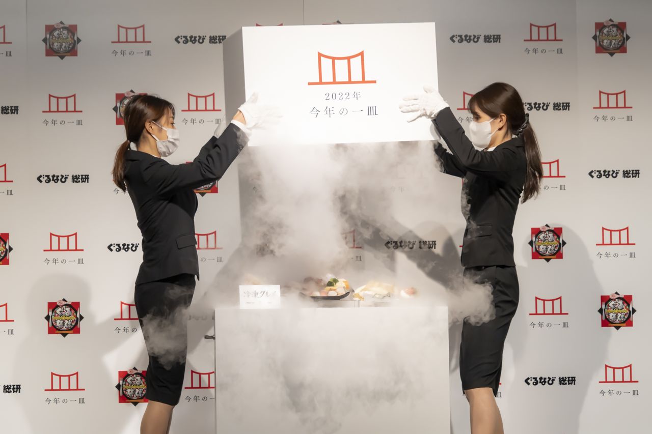 Two Gurunavi Research Institute employees unveil the "dish of the year" at a press event in Tokyo.