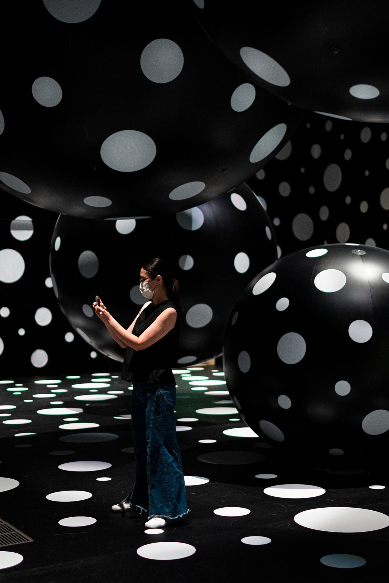 A visitor walks inside the "Dots Obsession—Aspiring to Heaven's Love" installation. 
