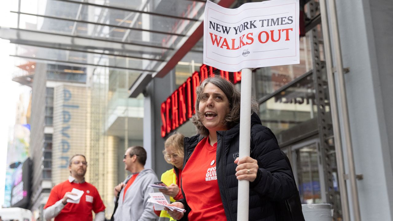 Stacy Cowley holds a sign outside the New York Times building in Manhattan, New York, U.S., December 8, 2022.  