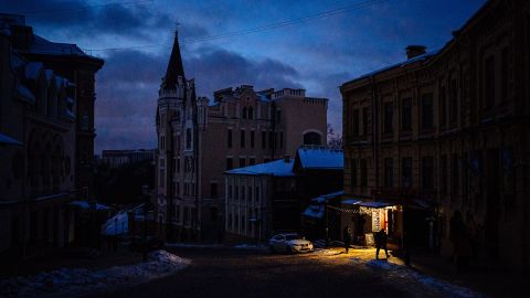 Люди йдуть вулицею в центрі Києва 6 грудня 2022 року. Через російські атаки енергомережа України балансує на межі колапсу, що призводить до частих відключень.