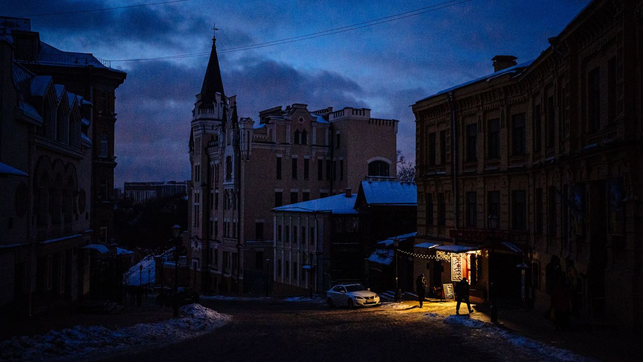 People walk down a  street in downtown Kyiv on December 6, 2022. Russian attacks have left Ukraine's energy grid teetering on the brink of collapse, forcing repeated blackouts.