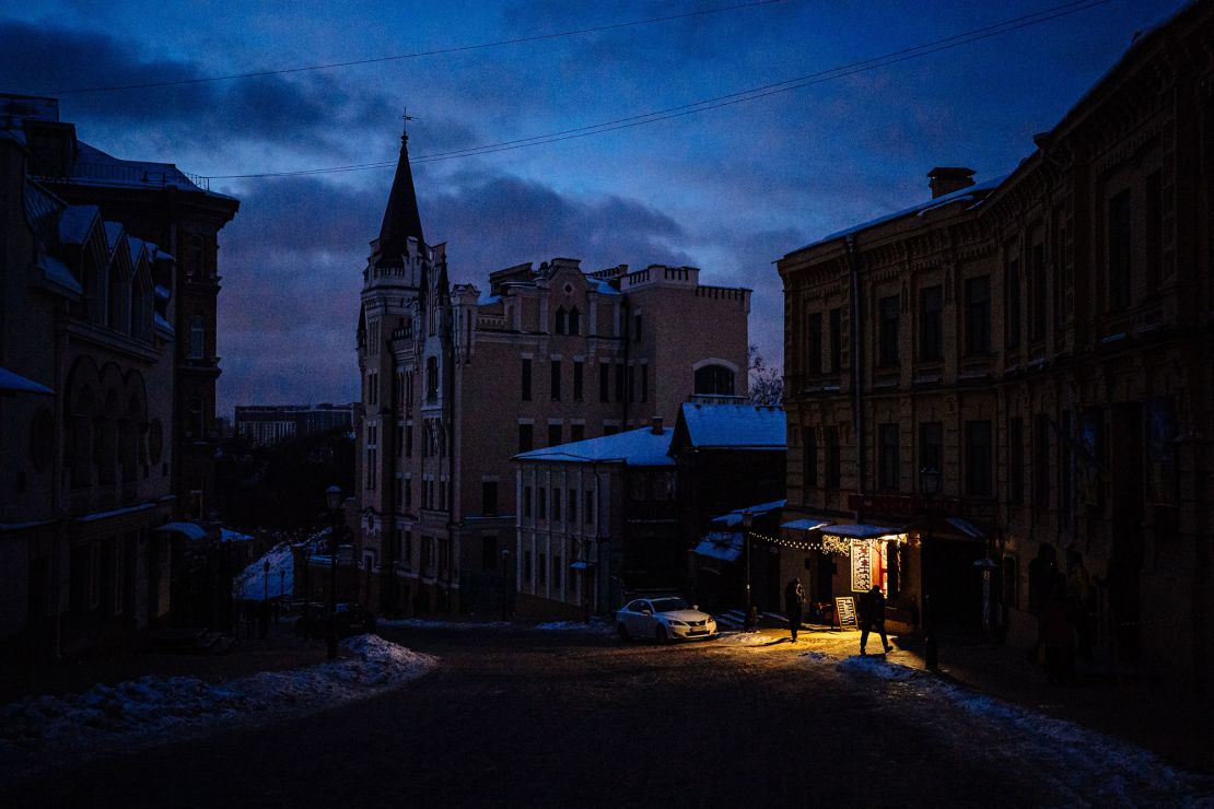 People walk down a street in downtown Kyiv on December 6, 2022. Russian attacks have left Ukraine's energy grid teetering on the brink of collapse, forcing repeated blackouts.