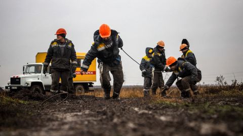 Робітники ремонтують високовольтні лінії електропередач, обірвані нещодавніми ракетними ударами під Одесою 7 грудня 2022 року під час вторгнення Росії в Україну.