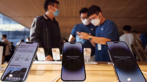 A customer talks to sales assistants in an Apple store as the new iPhone 14 models go on sale in Beijing, China, September 16, 2022. 