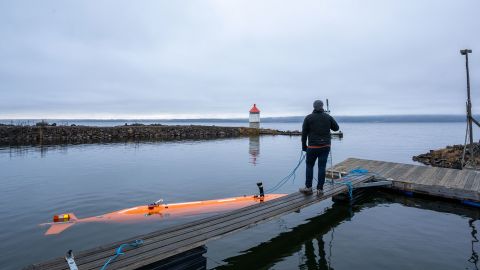 An autonomous underwater vehicle called Hugin (left) monitors a Norwegian lake.