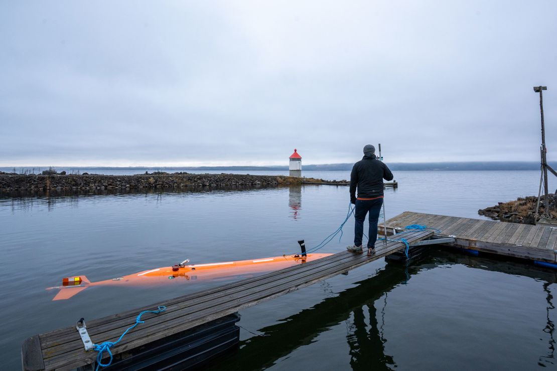 An autonomous underwater vehicle named Hugin (left) surveys a Norwegian lake.