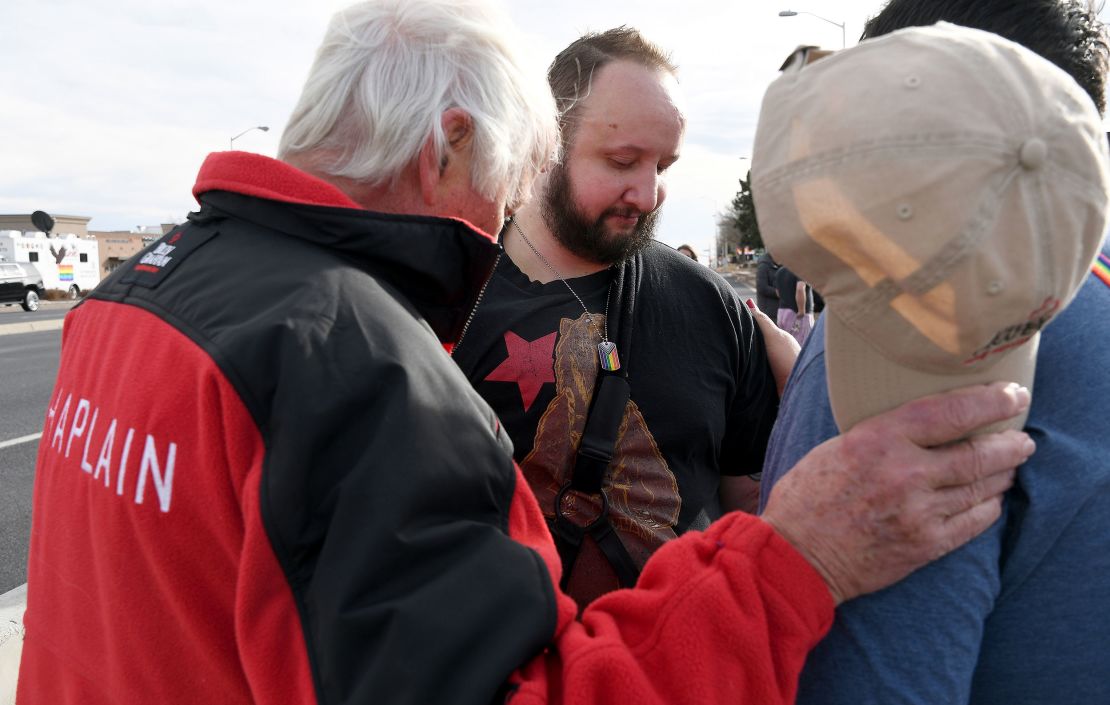 James Slaugh (center) prays with others at a memorial outside Club Q on November 23, 2022.