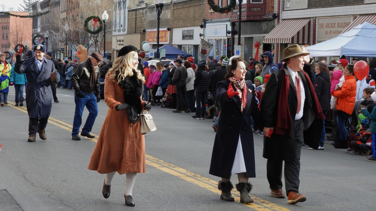 Locals who are dressed as characters from "It's a Wonderful Life" greet the crowd as they walk through downtown Seneca Falls during the 2017 festival parade.