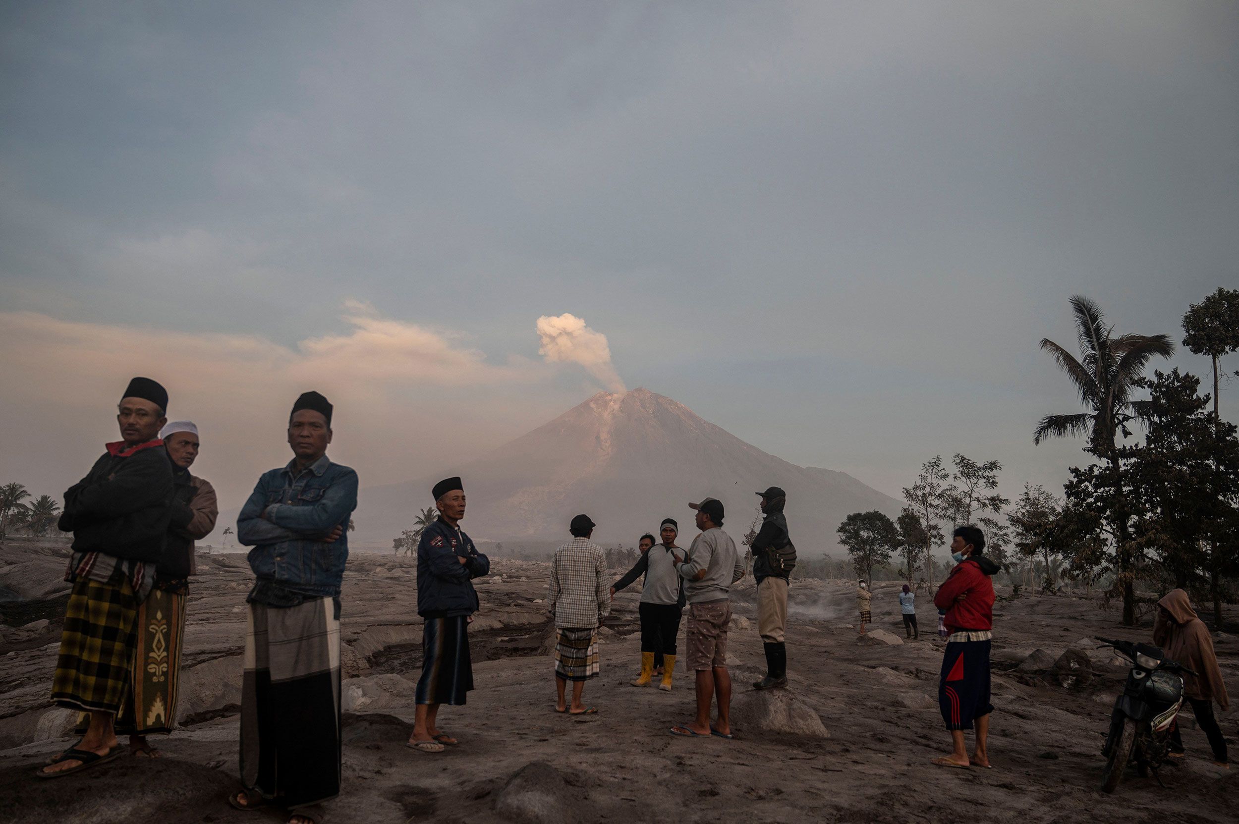 People stand in front of Mount Semeru a day after its volcanic eruption in Indonesia's East Java province on Sunday, December 4.