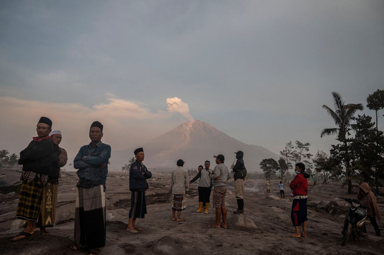 People stand in front of Mount Semeru a day after its volcanic eruption in Indonesia's East Java province on Sunday, December 4. <a href="https://www.cnn.com/2022/12/04/asia/indonesia-semeru-volcano-erupts-intl/index.html" target="_blank">The eruption</a> prompted nearly 2,000 people to evacuate their homes, authorities said. 