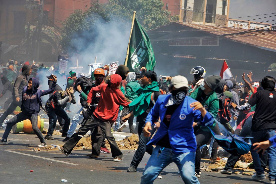 Protesters throw rocks at riot police on September 24, 2019, as demonstrations in Jakarta and other cities take place against proposed changes to Indonesia's criminal code laws. The changes were later watered down, but remain controversial.