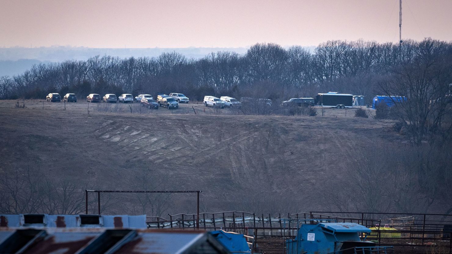 A line of vehicles parked near the rural Iowa site where authorities were searching for human remains said to have been buried there by a serial killer. They said they found nothing of concern there.