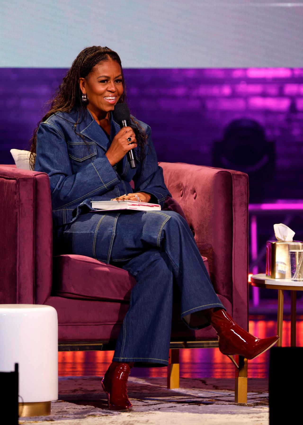 Former First Lady Michelle Obama speaks onstage during "The Light We Carry" book tour wearing a double denim Ganni ensemble. 
