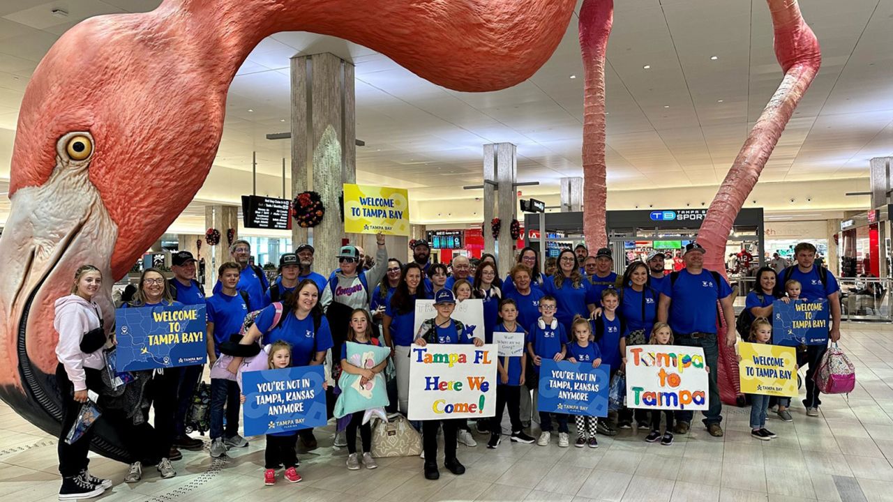 The residents of Tampa, Kansas, gather for a photo at the Tampa International Airport in Florida.