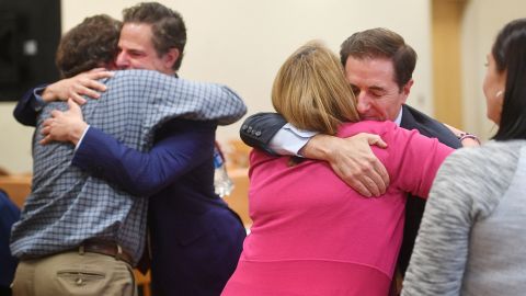 Plaintiff William Sherlach hugs attorney Josh Koskoff while plaintiff Nicole Hockley hugs attorney Chris Mattei following the jury verdict and reading of monetary damages in the Alex Jones defamation trial in Waterbury, Connecticut, on October 12, 2022.