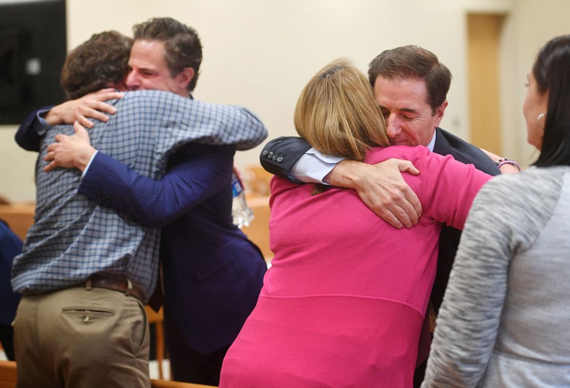 Plaintiff William Sherlach hugs attorney Josh Koskoff while plaintiff Nicole Hockley hugs attorney Chris Mattei following the jury verdict and reading of monetary damages in the Alex Jones defamation trial in Waterbury, Connecticut, on October 12, 2022.