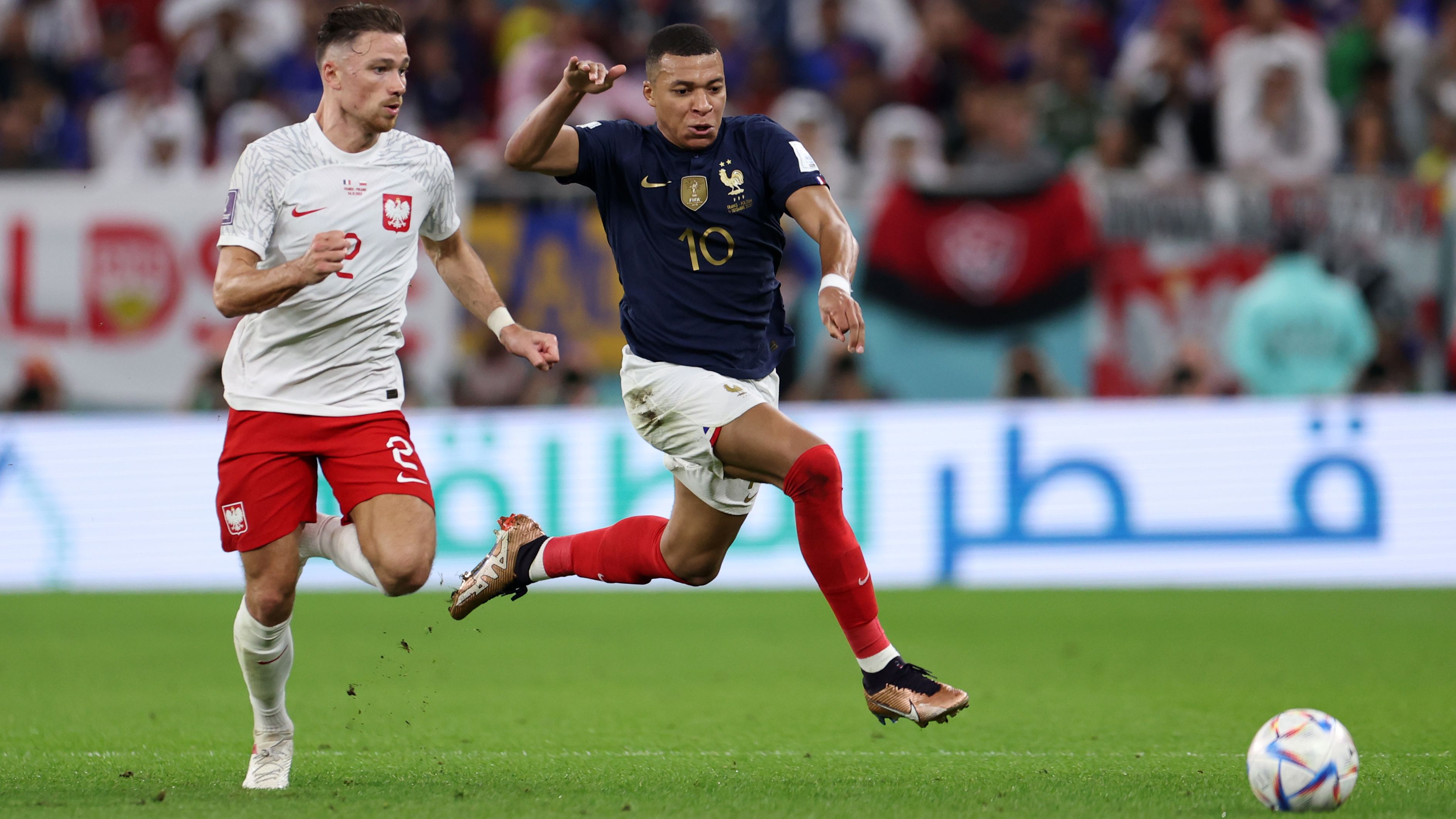 Catch him if you can ... Mbappé runs with the ball under pressure from Poland's Matty Cash. 