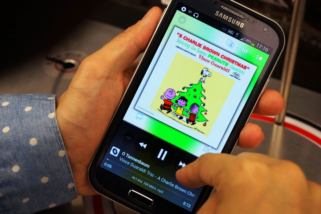 A woman listens to music from "A Charlie Brown Christmas" on her phone in 2013.