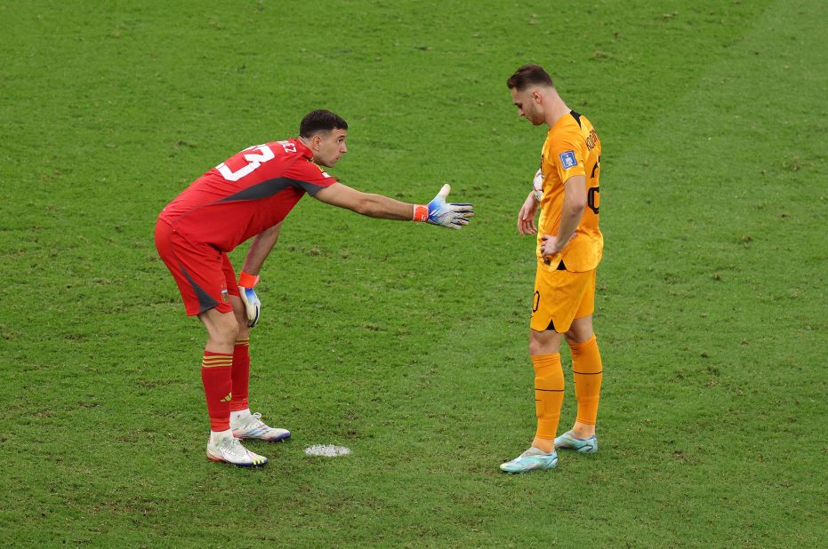 Argentina goalkeeper Emiliano Martinez tries to shake Teun Koopmeiners' hand during the shootout.
