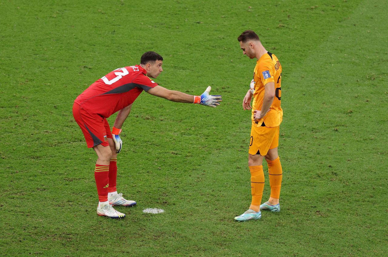 Argentina goalkeeper Emiliano Martinez tries to shake Teun Koopmeiners' hand during the shootout.