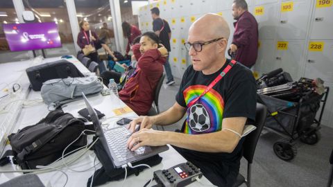 Wahl wearing a rainbow-colored t-shirt while working at Qatar 2022. 
