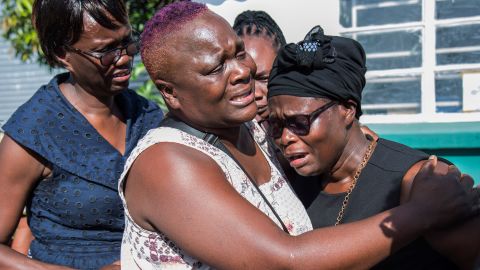 Lemekani Nyirenda's mother, Florence Nyirenda, is comforted by family members at the airport in Lusaka on 11 December.