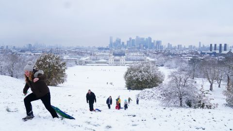 People sledding in the snow in Greenwich Park, London on Monday.