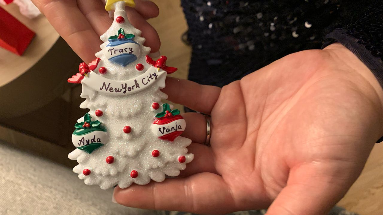 Ayda Zugay holds a custom Christmas ornament Tracy Peck gave to the sisters to commemorate their reunion.