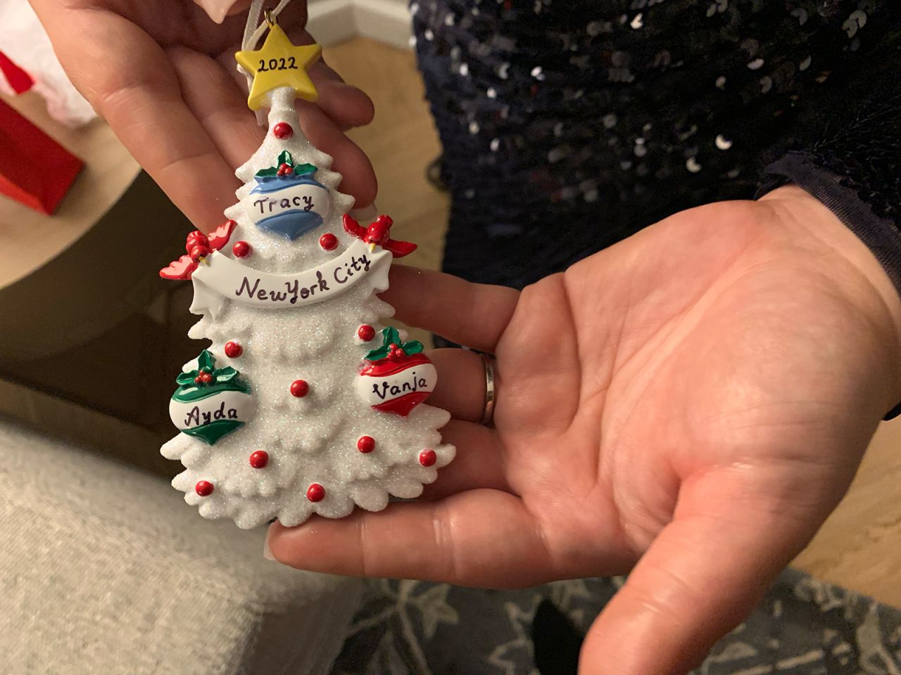 Ayda Zugay holds a custom Christmas ornament Tracy Peck gave to the sisters to commemorate their reunion.