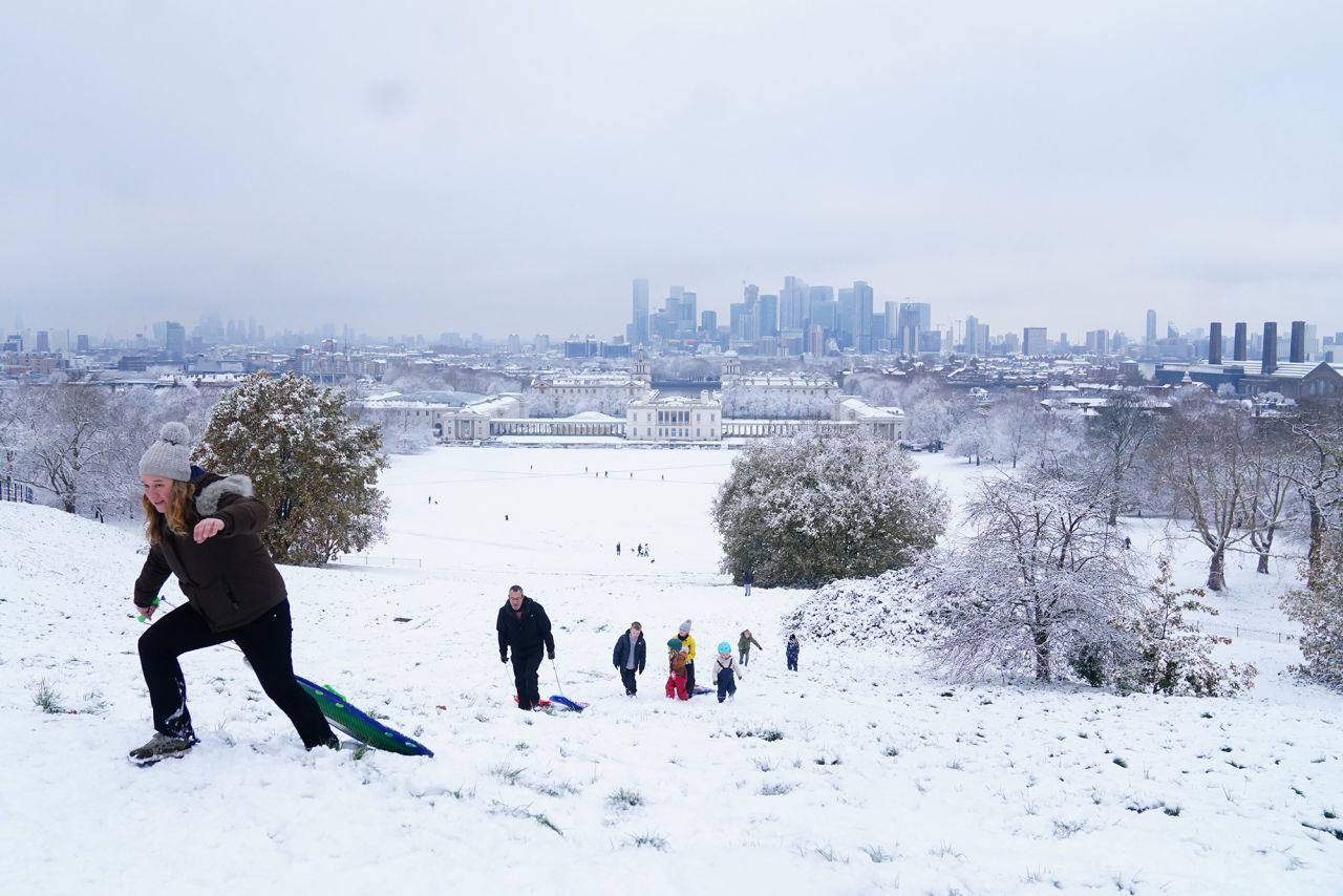 People carry sleds up a hill in London's Greenwich Park. The arrival of snow two weeks before Christmas brought a festive atmosphere to the capital's parks and streets.