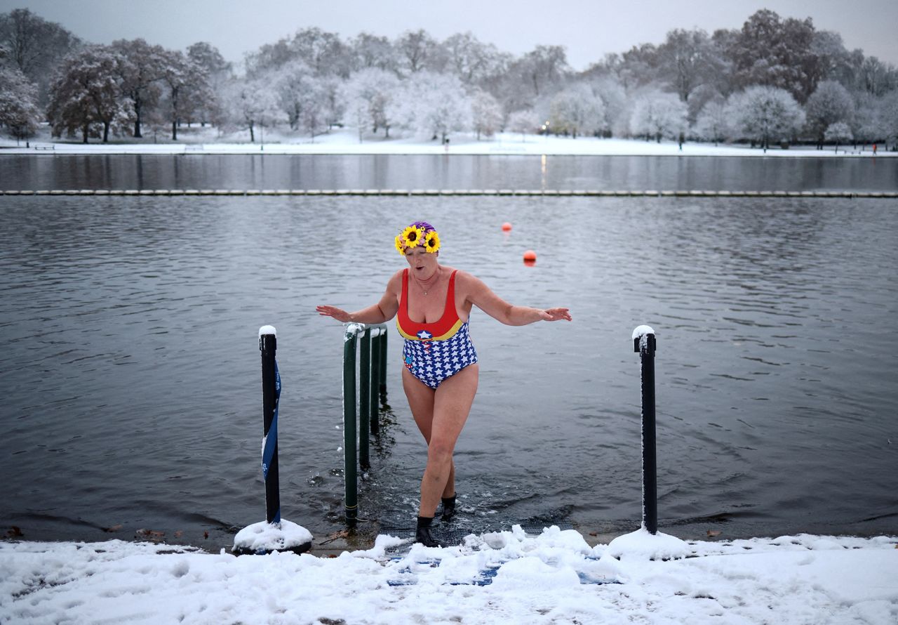A swimmer dips her feet in The Serpentine lake in London on Monday, December 12. <a href="https://www.cnn.com/2022/12/12/uk/gallery/uk-snow/index.html" target="_blank">Snow blanketed London and large parts of the United Kingdom</a> on Monday, shutting schools and causing widespread disruption across a country struggling through a winter energy crisis.