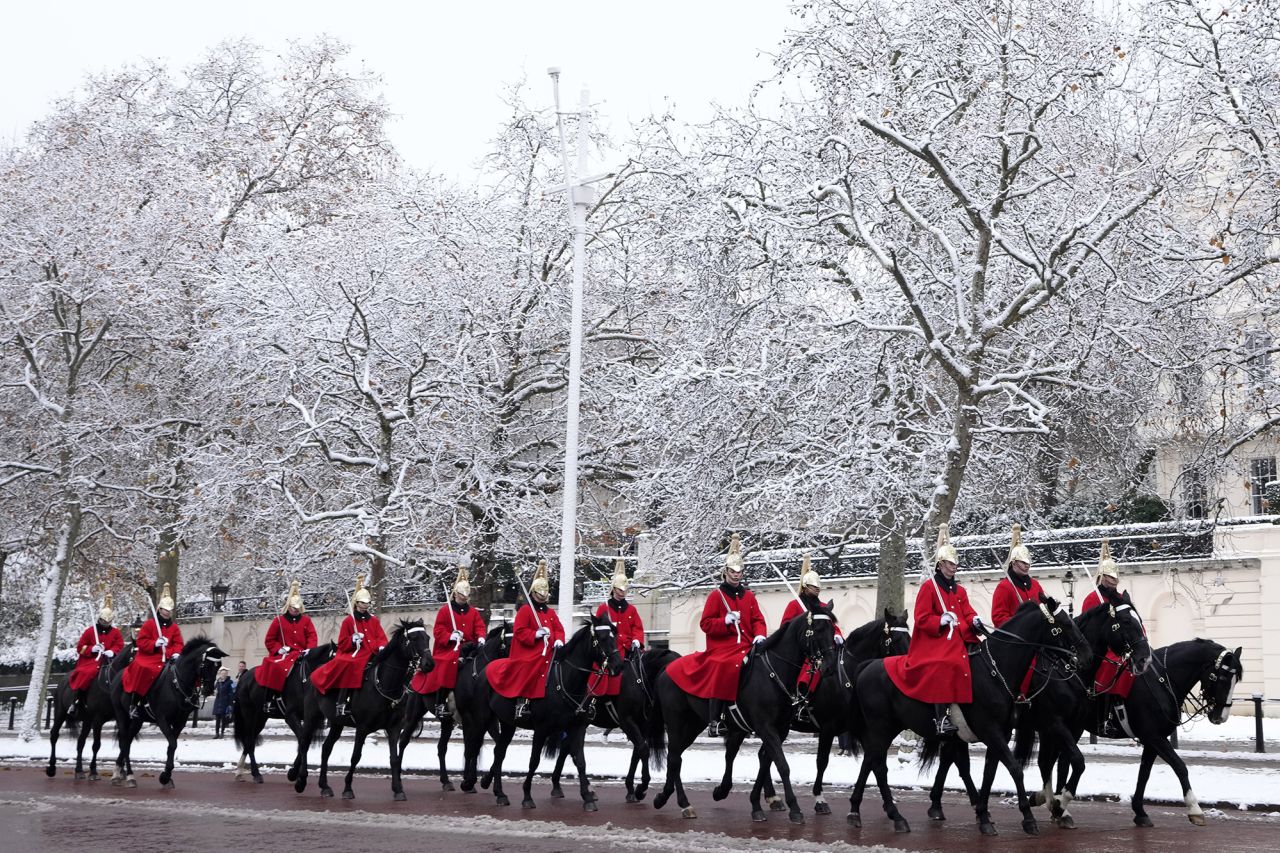 Mounted soldiers ride along the Mall in central London during the changing of The King's Guard.