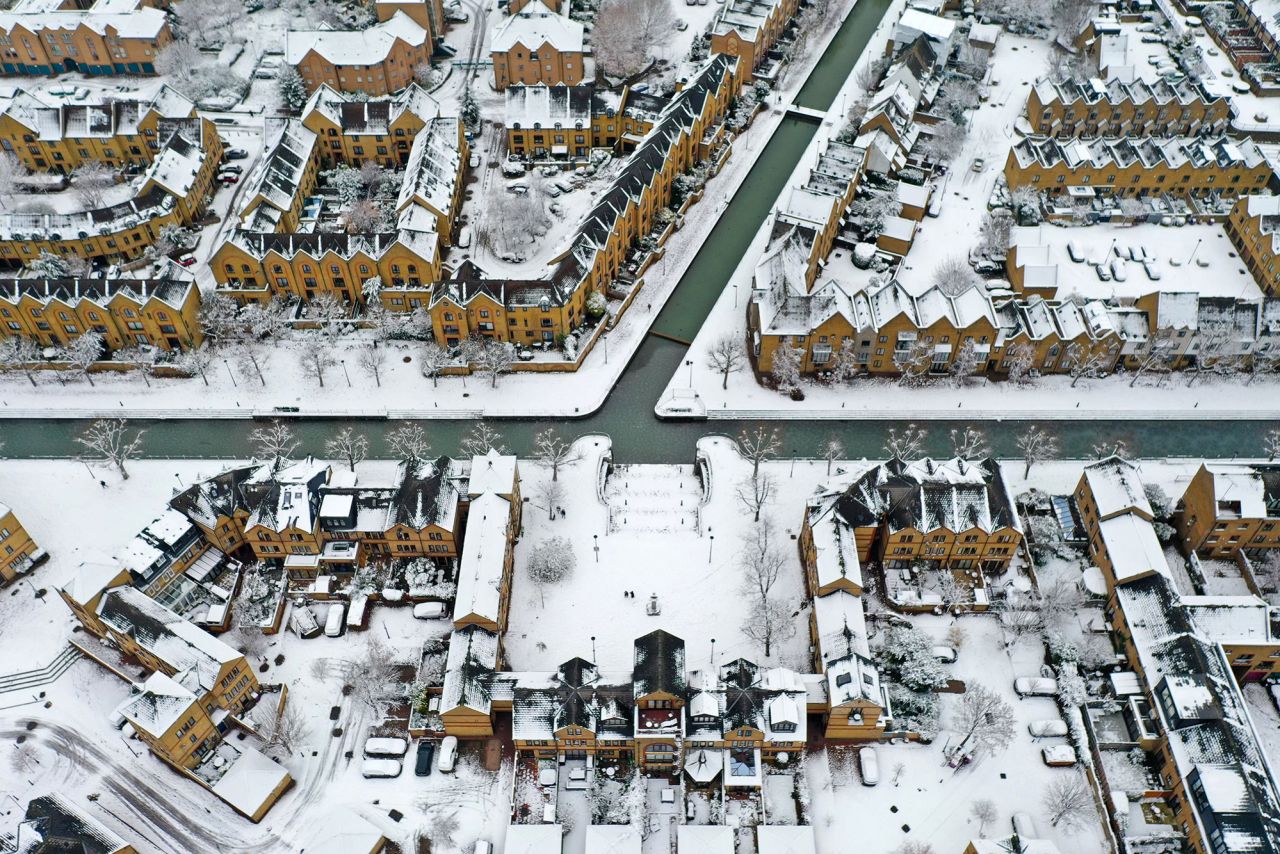 Snow covers rooftops and roads along a canal in east London's Wapping.