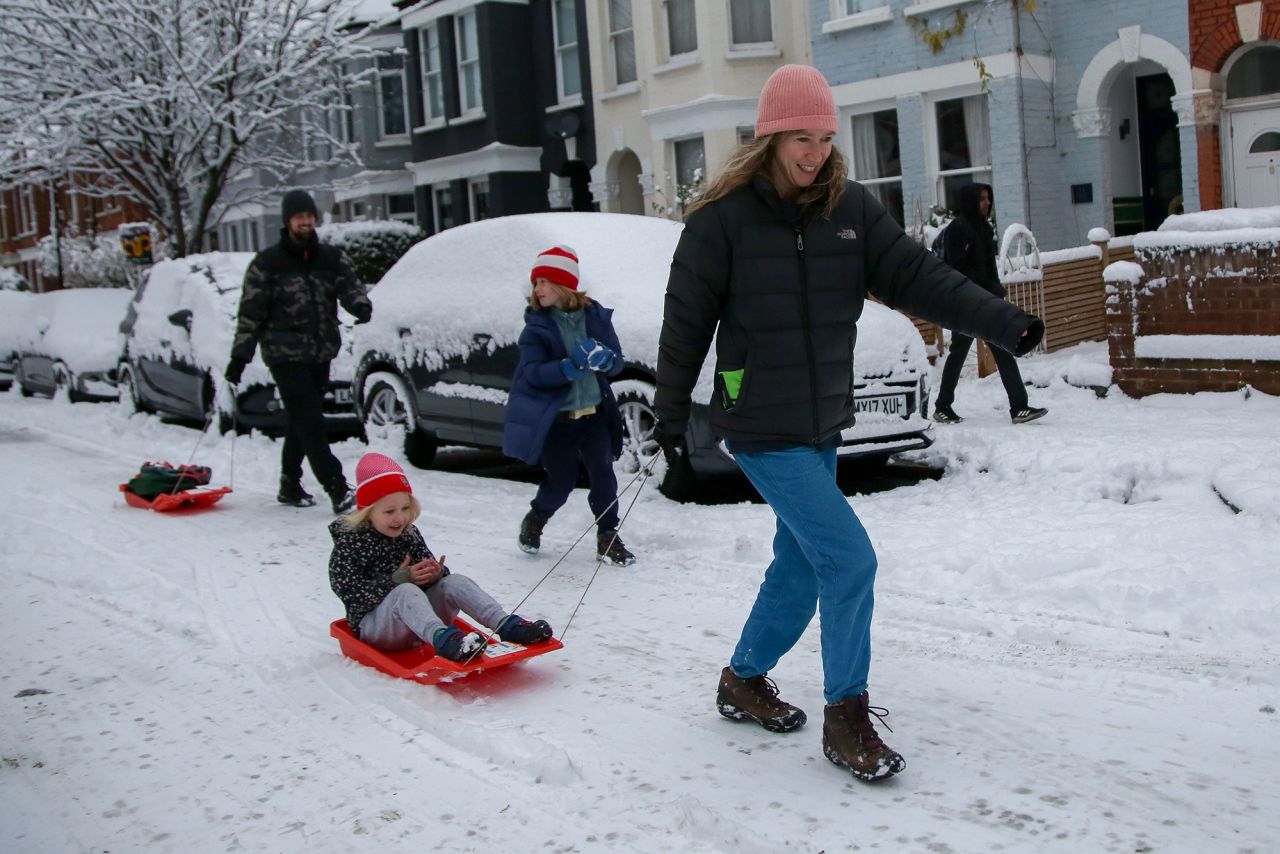 A mother pulls a sled with her daughter in north London. 