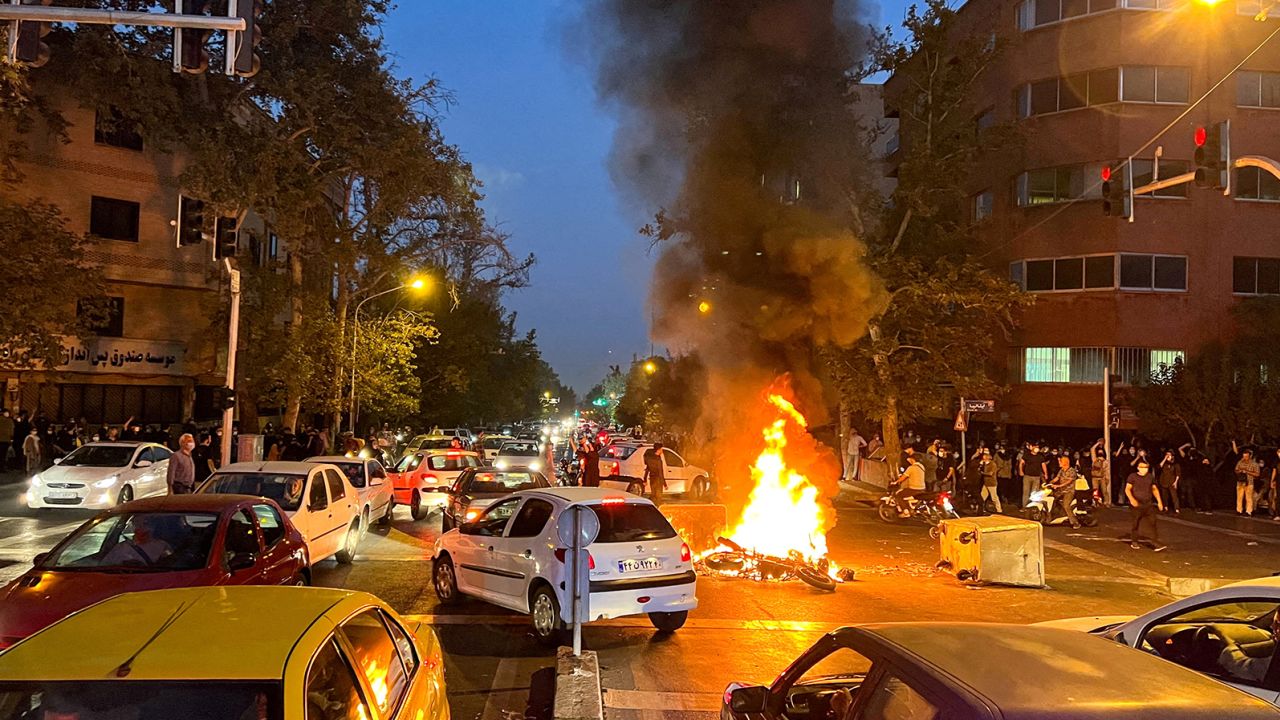 A police motorcycle burns during a protest over the death of Mahsa Amini, a woman who died after being arrested by the Islamic republic's "morality police" in Tehran on September 19, 2022.