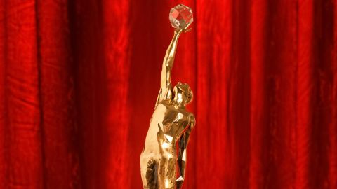 The bronze trophy features a player reaching for a crystal basketball.