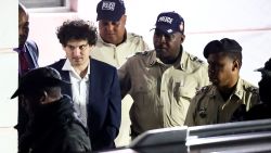 Sam Bankman-Fried, who founded and led FTX until a liquidity crunch forced the cryptocurrency exchange to declare bankruptcy, is escorted out of the Magistrate Court building in Nassau, Bahamas December 13, 2022. REUTERS/Dante Carrer